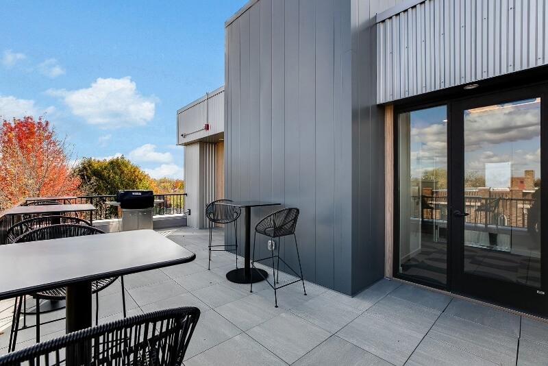 the balcony with seating and a community grill