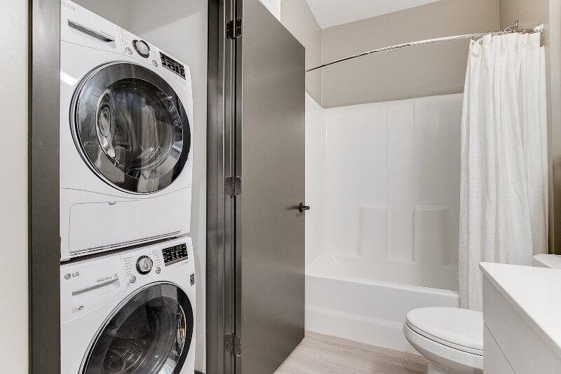 an apartment bathroom looking at the washer and dryer